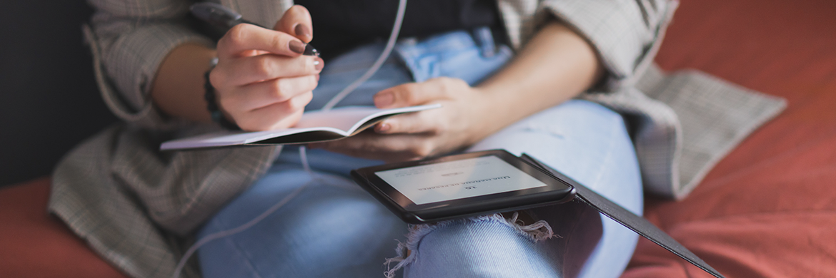 Woman listening to headphones and reading ebook on tablet